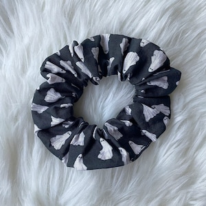 Op de afbeelding: Een zwarte scrunchie met een wit spookpatroon.
