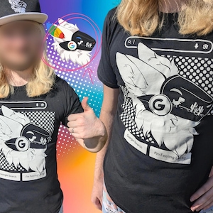 Könnte beinhalten: Ein schwarzes T-Shirt mit einem weißen Grafikdruck eines stilisierten Tierkopfes, der ein Visier mit einem Google-inspirierten Logo trägt. Das Design umfasst eine Suchleiste, ein Dinosaurier-Symbol, Kaktus-Silhouetten und den Text Google Search.