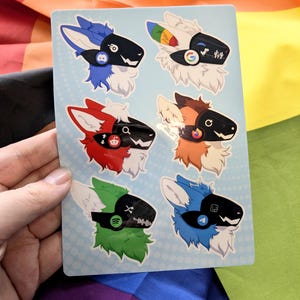 May include: A rectangular sticker sheet featuring six individual illustrations of anthropomorphic creatures with robotic visors. Each character displays a different colour scheme and a unique tech-themed logo on its visor, including Discord, Google, Reddit, Firefox, Spotify, and Telegram icons.