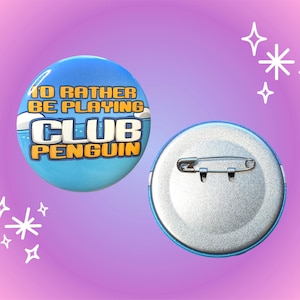 May include: A round blue button with the text "I'D RATHER BE PLAYING CLUB PENGUIN" in yellow and white. The back of the button is silver with a safety pin clasp. The background is a gradient of pink and purple.