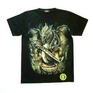 Könnte beinhalten: Schwarzes T-Shirt mit einem grafischen Aufdruck eines silbernen Drachen, der ein Schwert hält. Der Drache ist von Flammen und Rauch umgeben. Das T-Shirt hat einen kleinen gelben Kreis mit dem Text "Sun City" in Schwarz.