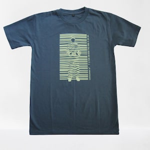 May include: A dark blue t-shirt with a light green graphic of a person standing inside a barcode. The barcode has numbers and the text "Copyright 2007 7 2 1 4 5 6 9 8 7 6 5 4 3 2 1".