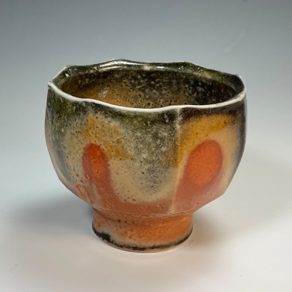 hand thrown porcelain faceted tea bowl 4x3x3 with shino carbon trap glaze fired in reduction to 2200 degrees F in a gas kiln
