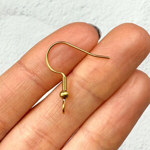 May include: Gold-toned earring hook with a small ball at the end.