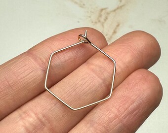 Puede incluir: Pendiente de aro hexagonal de oro con un aro de unión.