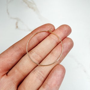 May include: A pair of gold hoop earrings. The earrings are simple and elegant, and they would be a great addition to any jewelry collection.