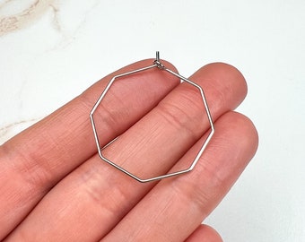May include: Silver octagon hoop earrings. The earrings are simple and elegant, and they would be a great addition to any jewelry collection.