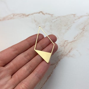 May include: Gold-toned metal pendant shaped like a diamond with a solid bottom section. The pendant has a hole at the top for attaching a chain or cord.