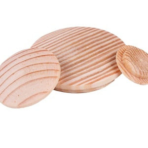 May include: Three wooden lids with a grooved pattern. The lids are different sizes and are made of light brown wood.