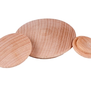 Puede incluir: Tres círculos de madera sin terminar de varios tamaños. El más grande es un óvalo plano, el mediano es un óvalo más pequeño y el más pequeño tiene una parte superior redondeada y elevada. Todos tienen vetas de madera visibles y un color marrón claro.