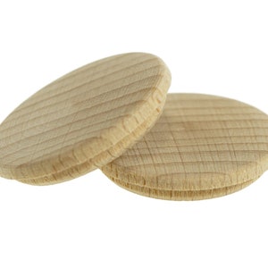 May include: Two wooden round discs, stacked on top of each other. The discs are light brown and have a wood grain pattern.