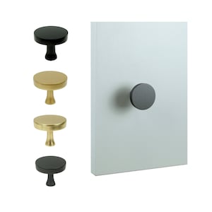 May include: Four cabinet knobs, two black and two gold, with a round shape and a short stem. The knobs are shown against a white background.