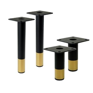 Könnte beinhalten: Vier schwarze Metallmöbelbeine mit goldenen Akzenten. Jedes Bein hat eine quadratische Basis und einen runden, zylindrischen Schaft.