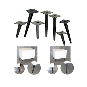 May include: Set of five black metal furniture legs with square plates. The legs are tapered and range in height from 10 to 15 inches. The legs are shown attached to two white cube-shaped nightstands.