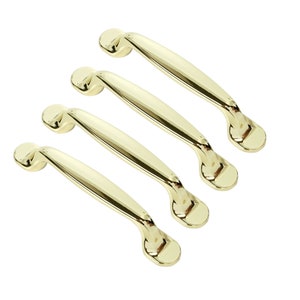Könnte beinhalten: Vier goldfarbene Schrankgriffe mit einem einfachen, geschwungenen Design. Die Griffe sind in einer Reihe angeordnet, wobei der größte Griff oben und der kleinste Griff unten ist.