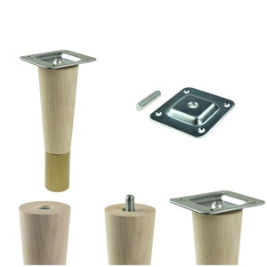 Könnte beinhalten: Ein Satz von vier Möbelbeinen aus Holz mit Messing-Finish. Jedes Bein hat eine quadratische Metallplatte mit Schraubenlöchern zur Befestigung an Möbeln. Die Beine sind 15 cm hoch.