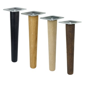 Op de afbeelding: Vier meubelpoten in verschillende afwerkingen: zwart, naturel hout, licht hout en donker hout. Elke poot heeft een metalen bevestigingsplaat.