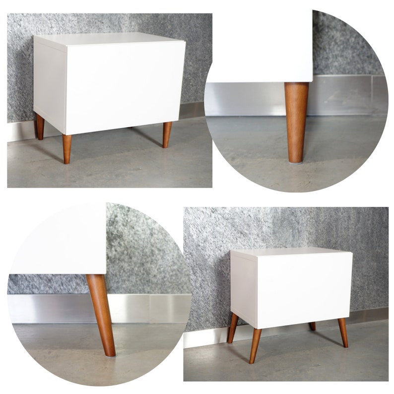 May include: White nightstand with four wooden legs. The nightstand has a simple, modern design.