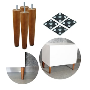 May include: Four wooden legs with metal mounting plates, shown assembled on a white cabinet with a drawer. The cabinet is on a gray surface.