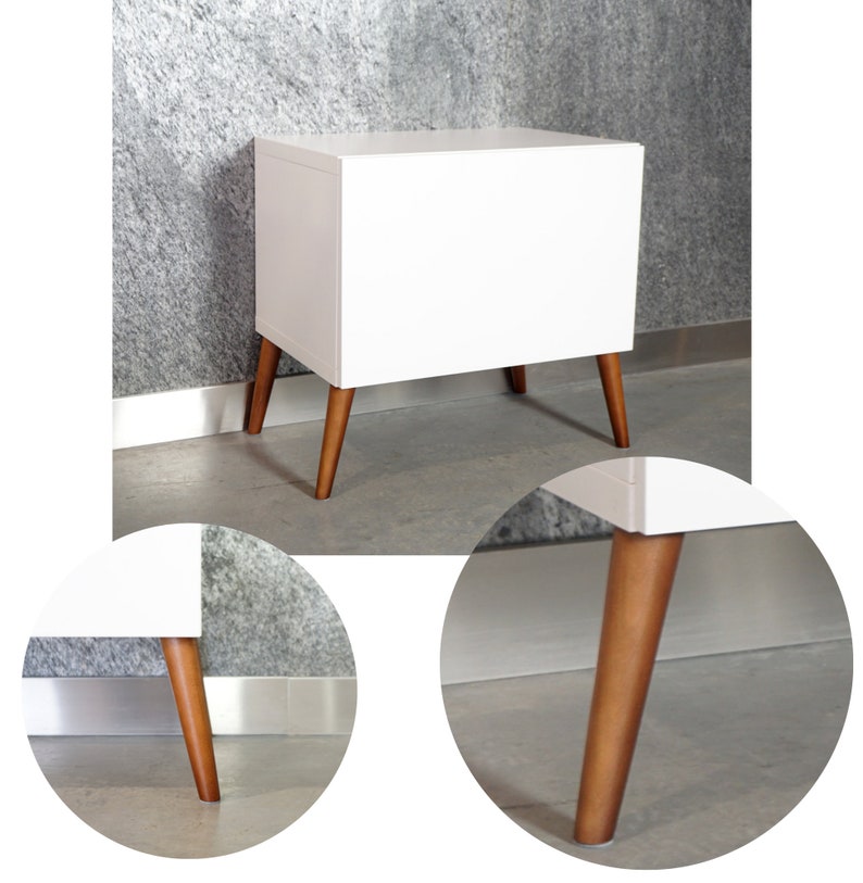 May include: White bedside table with a single drawer and four wooden legs. The table has a modern design with a white finish and natural wood legs.