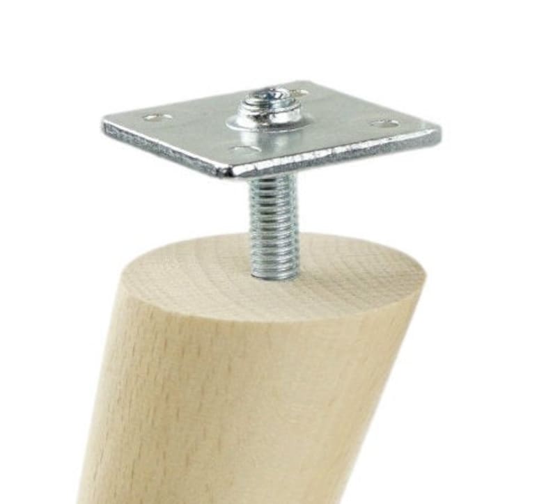 May include: A wooden furniture leg with a metal screw and plate attachment. The leg is light brown and the metal is silver.