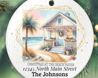 Puede incluir: Adorno navideño redondo y blanco con una imagen de una casa en la playa. La imagen muestra una casa con una palmera, playa y el texto "CHRISTMAS AT THE BEACH HOUSE", dirección, apellido y año. Acentos dorados.