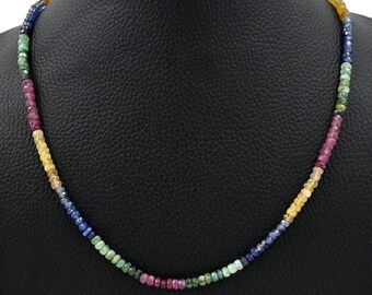 Könnte beinhalten: Eine mehrfarbige Edelstein-Halskette mit blauen, grünen, roten und gelben Perlen. Die Halskette wird auf einer schwarzen Mannequin-Büste präsentiert.