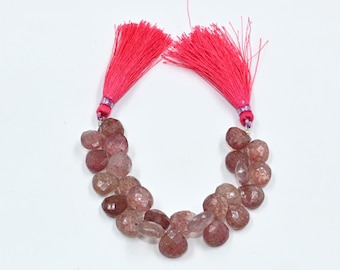 May include: A strand of faceted, heart-shaped strawberry quartz beads in shades of translucent pink and reddish-brown, featuring two bright neon pink decorative tassels attached at the top ends of the bead strand.