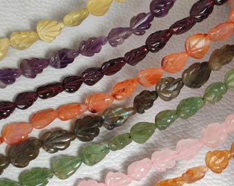 May include: A strand of gemstone beads, each carved into a leaf shape. The beads are in various colours, including purple, red, orange, green, pink, and yellow.