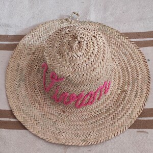May include: A straw hat with a pink embroidered word "Summer" on the front.