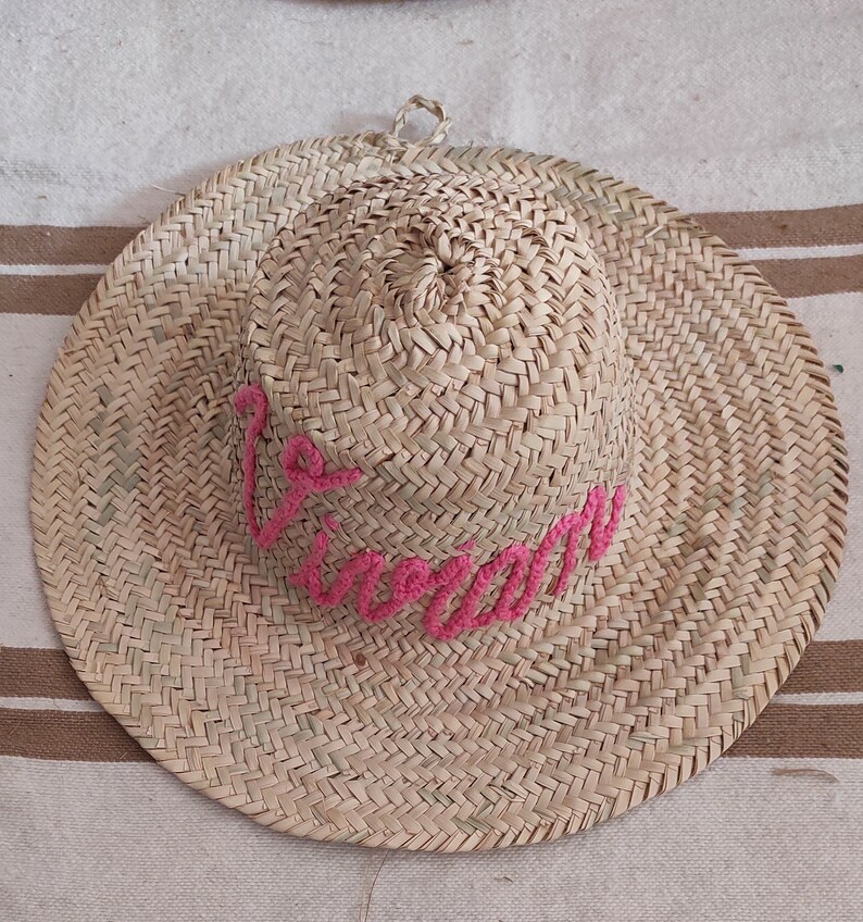 May include: A straw hat with a pink embroidered word "Summer" on the front.