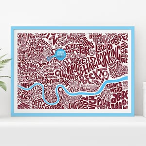 Puede incluir: Una impresión enmarcada de un mapa de Londres, con nombres de barrios en burdeos sobre fondo blanco. Un río azul atraviesa el mapa y el marco es azul claro. Una pieza decorativa.