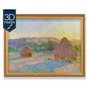 May include: A framed landscape painting featuring two large haystacks in a field under a soft sky. The artwork uses impressionistic brushstrokes in shades of purple, blue, yellow, and green. The painting is enclosed in an ornate gold frame.