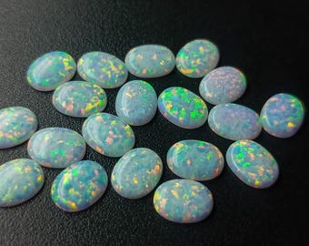 Biały syntetyczny, laboratoryjnie tworzony, sypki, błyszczący opal w kształcie owalu, kaboszon, 9 x 7 mm, hurtowa partia OPAL00098