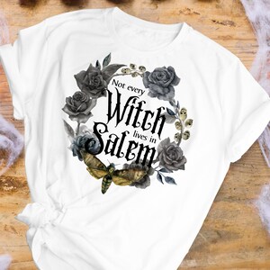 May include: White t-shirt with a black and gray floral design and the text "Not every Witch lives in Salem".
