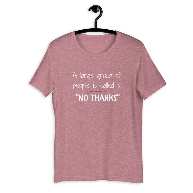 Puede incluir: Una camiseta de color rosa claro jaspeada con un gr&aacute;fico blanco que dice "A large group of people is called a "NO THANKS""