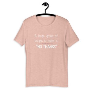 Puede incluir: Una camiseta rosa con el texto "A large group of people is called a "NO THANKS""