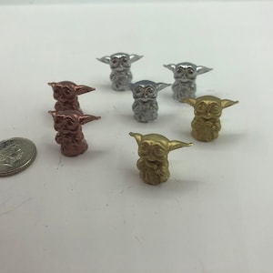 May include: A set of seven small figurines of a popular fictional character. The figurines are painted in silver, gold, and copper.