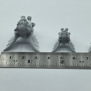 Może przedstawiać: Trzy szare figurki gargulc&oacute;w o r&oacute;żnych rozmiarach, ustawione na linijce. Największy gargul jest wysoki na 3,8 cm, średni gargul jest wysoki na 2,5 cm, a najmniejszy gargul jest wysoki na 1,9 cm.