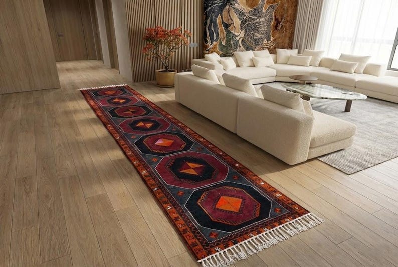 a modern living room with a large white sectional sofa, a colorful rug, and a wooden floor.
