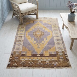 a cozy living room with a large, colorful rug on the floor, a wooden chair, and a wooden coffee table.