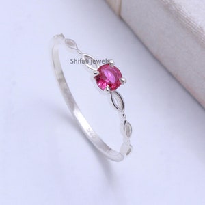 May include: A white ceramic mug with a black handle and the text "But First, Coffee" in a bold, black font. The mug is set against a blurred background, suggesting a cozy setting.