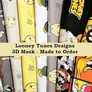 May include: A collection of Looney Tunes 3D mask fabrics in various colors and patterns. The fabrics feature characters like Bugs Bunny, Tweety Bird, and Marvin the Martian. The text "Looney Tunes Designs 3D Mask - Made to Order" is displayed.