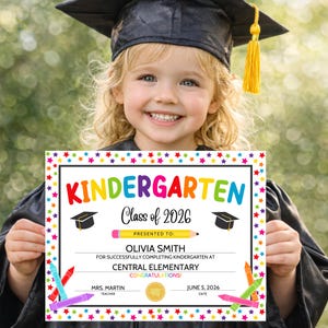 Kindergarten graduation child holding diploma certificate wearing cap and gown celebrating graduation day