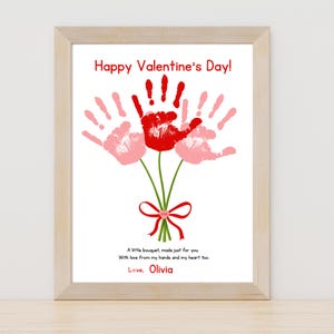 May include: A framed Valentine's Day print featuring a bouquet of handprints in red and pink, with green stems and a red bow. The text "Happy Valentine's Day!" is at the top, with a message and the name "Olivia" at the bottom.