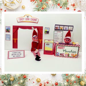 May include: A Christmas-themed elf movie set with a red and white striped candy cane cinema sign, a red and white striped popcorn machine, and a red and white striped concession stand with the text "Merry Munchies".