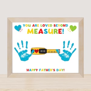 Könnte beinhalten: Ein gerahmter Druck mit dem Text "YOU ARE LOVED BEYOND MEASURE!" in bunten Buchstaben. Das Bild enthält blaue Handabdrücke, Herzen und ein gelbes Maßband. Die Worte "HAPPY FATHER'S DAY!" stehen unten.