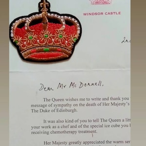May include: A handwritten letter from Windsor Castle with a red and gold embroidered crown on the top. The letter reads "Dear Mr Mc Donnell, The Queen wishes me to write and thank you message of sympathy on the death of Her Majesty's The Duke of Edinburgh. It was also kind of you to tell The Queen a little about your work as a chef and of the special ice cube you made for her while she was receiving chemotherapy treatment. Her Majesty greatly appreciated the warm sentiment and I am to thank you, once again, for your letter. Beautiful Yours sincerely"