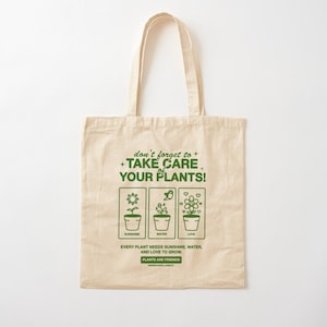 May include: A beige tote bag with a green graphic that says "don't forget to + TAKE CARE of YOUR PLANTS!" with three icons representing sunshine, water, and love. The text below the icons says "Every plant needs sunshine, water, and love to grow. PLANTS ARE FRIENDS!"