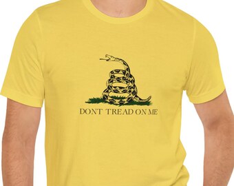 May include: A yellow t-shirt featuring a green and black snake graphic with the text "Don't Tread On Me".